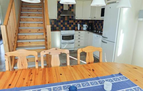 a kitchen with a wooden table and two chairs at 4 Bedroom Amazing Home In Vessigebro in Ås