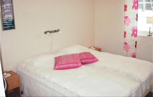 a bedroom with a pink pillow on a bed at 4 Bedroom Amazing Home In Vessigebro in Ås
