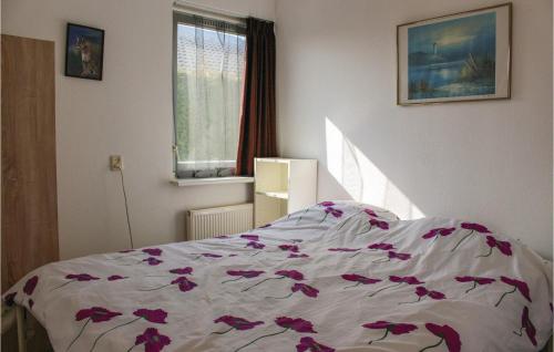 een slaapkamer met een bed met paarse bloemen erop bij Awesome Home In Tzummarum With 3 Bedrooms, Wifi And Outdoor Swimming Pool in Tzummarum