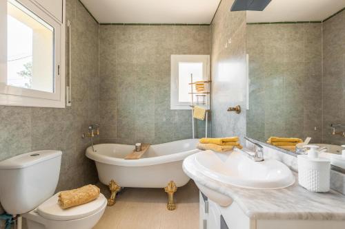 a bathroom with a tub and a sink and a toilet at Villallop in Olivella
