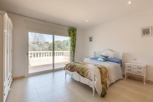 a bedroom with a bed and a large window at Villallop in Olivella