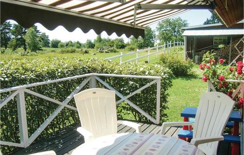 a patio with two chairs and a table and a fence at 2 Bedroom Amazing Home In Vimmerby in Vimmerby