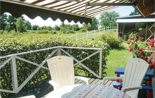 ビンメルビューにあるTwo-Bedroom Holiday Home In Vimmerbyのパティオ(椅子2脚、テーブル、フェンス付)