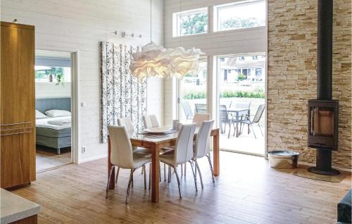 雪平茲克的住宿－Awesome Home In Kpingsvik With Kitchen，一间带桌椅和吊灯的用餐室