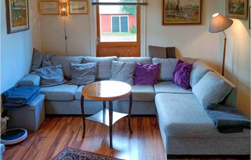 a living room with a couch and a table at Holiday Home Sandsjöfors 47 in Holsteryd