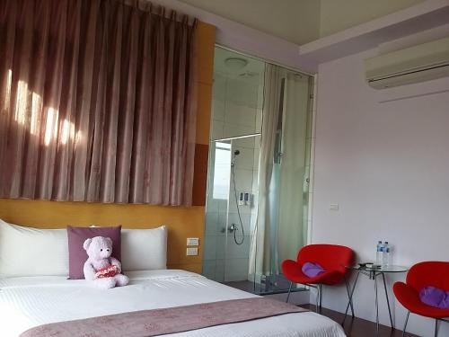 a teddy bear sitting on a bed in a bedroom at Jing Xiang Hua Nong B&B in Dongshan