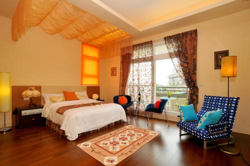 a bedroom with a bed and chairs and a window at Jing Xiang Hua Nong B&B in Dongshan