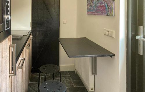a kitchen with a black counter and two stools at Gorgeous Home In Bunschoten-Spakenb in Bunschoten