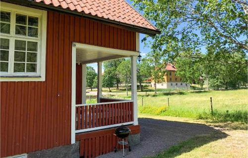 a red house with a balcony with a window at Cozy Home In Mantorp With Wifi in Mantorp