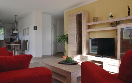 a living room with red chairs and a television at Fewo Schloss Bothmer in Kaschow