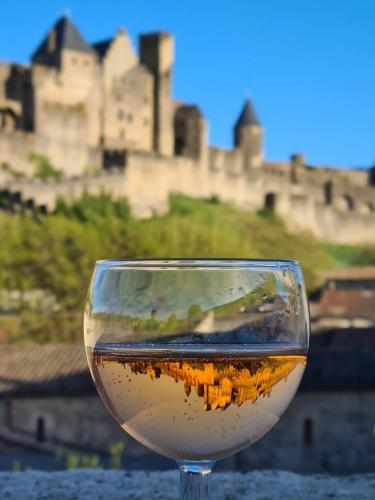 un verre de vin avec un château en arrière-plan dans l'établissement La Terrasse de Jules, à Carcassonne