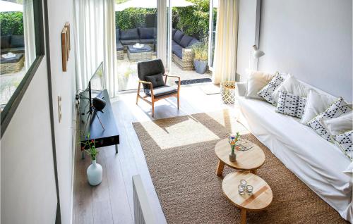 een woonkamer met een witte bank en een stoel bij Sandbanks in Bergen aan Zee