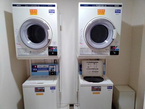 three washing machines and a washer and dryer in a room at Hotel Hanakomichi in Nara
