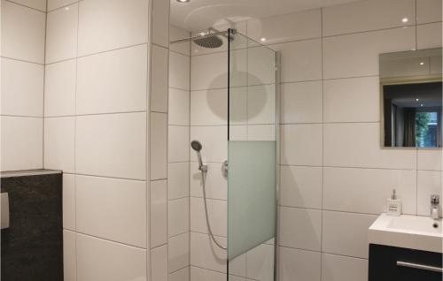 um chuveiro com uma porta de vidro ao lado de um lavatório em Oud Kempen Bungalow 183 em Stavenisse