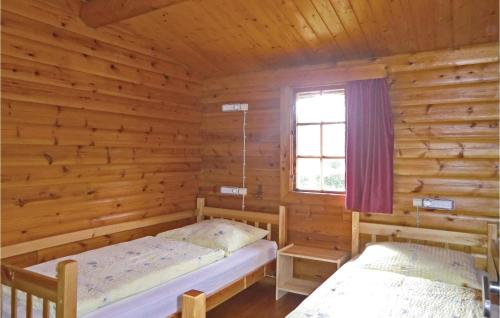 2 camas en una cabaña de madera con ventana en Mamet, en Waldbillig