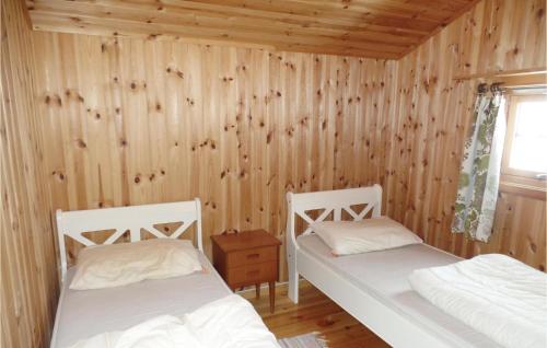 two beds in a room with wooden walls at Lovely Home In Ringebu With Kitchen in Odlo