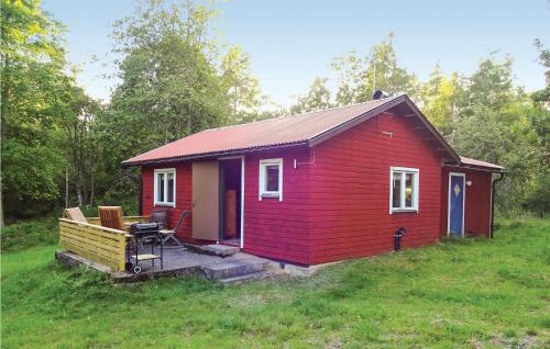 una casita roja en medio de un campo en Two-Bedroom Holiday Home In Brakne Hoby, en Smedamåla