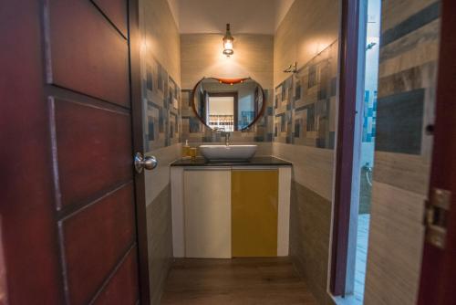 a bathroom with a sink and a mirror at mezzanine villa W/T Hot Tub Jacuzzi in Kālapettai