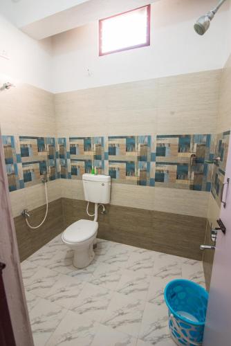 a bathroom with a white toilet in a room at mezzanine villa W/T Hot Tub Jacuzzi in Kālapettai