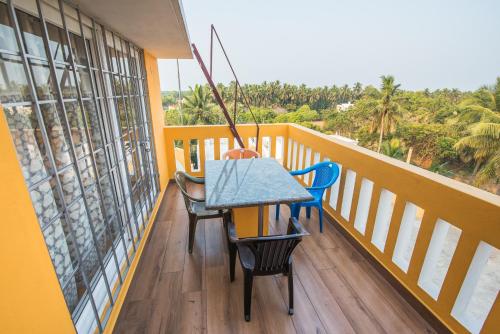 a porch with a table and chairs on a balcony at mezzanine villa W/T Hot Tub Jacuzzi in Kālapettai