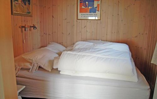 a bed in a room with white sheets and pillows at Holiday Home Åsgårdsstrand Damgt, in Åsgårdstrand