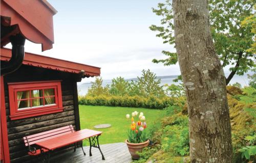 a log cabin with a bench next to a tree at Holiday Home Åsgårdsstrand Damgt, in Åsgårdstrand
