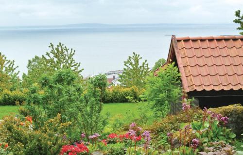 a garden with flowers and the ocean in the background at Holiday Home Åsgårdsstrand Damgt, in Åsgårdstrand