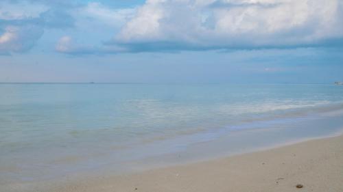 a beach with a cloudy sky and the ocean at Nongsa Village in Nongsa