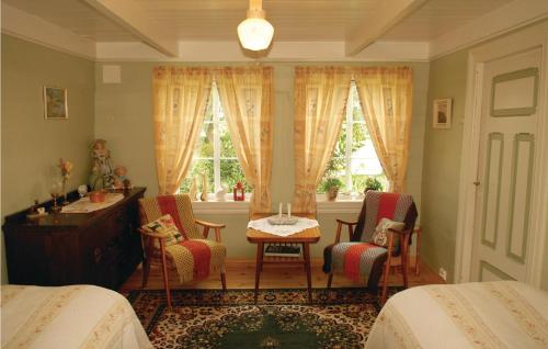 VanseにあるBeautiful Home In Vanse With Kitchenのベッドルーム1室(ベッド2台、テーブル、椅子付)