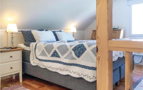 Beautiful Home In Eskilstuna With Kitchen في إسكيلستونا: غرفة نوم بسرير وبطانيات ووسائد زرقاء وبيضاء