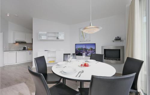 Un comedor blanco con una mesa y sillas blancas. en Dünenvilla 21, Whg 10, en Travemünde