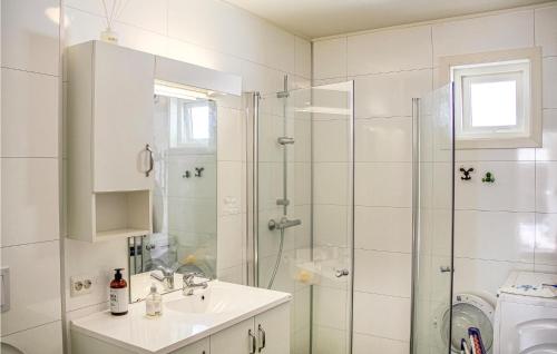 a white bathroom with a shower and a sink at 3 Bedroom Lovely Home In Farsund in Farsund