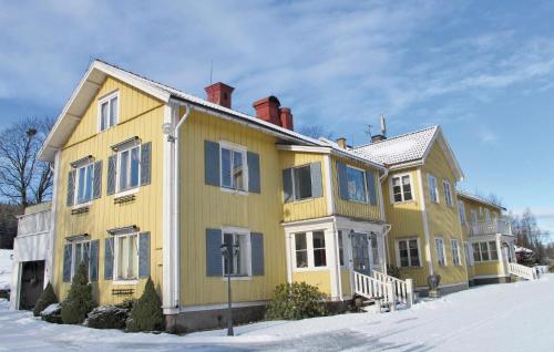 ein großes gelbes Haus mit blauen Fensterläden darauf in der Unterkunft Awesome Home In Gräsmark With Sauna in Gräsmark