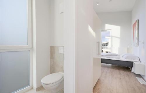 a white bathroom with a toilet and a mirror at Dünenvilla 1, Whg 5 in Travemünde