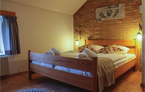 a bed in a bedroom with a brick wall at Vakantiewoning 12 in Simpelveld