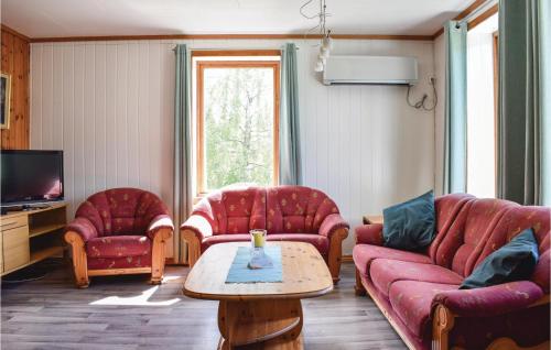 a living room with red couches and a coffee table at 4 Bedroom Beautiful Home In Steinstø in Steinstø