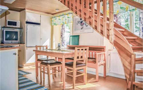 a kitchen with a table and chairs and a staircase at Nice Home In Katthammarsvik With 1 Bedrooms in Katthammarsvik