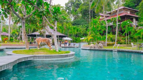 a zebra statue next to a pool in a resort at Nongsa Village in Nongsa