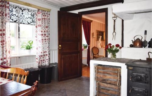 a kitchen with an open door and a table and a room at Lovely Home In Klippan With Sauna in Klippan