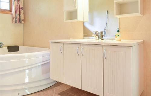 a white bathroom with a sink and a bath tub at Eikhaugen Gjestegard in Vinnes