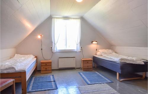 a attic room with two beds and a window at Holiday Home Nordtveitgrend Nedrevågen in Haugen