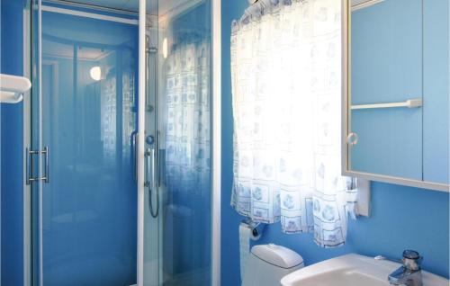 a blue bathroom with a shower and a sink at Stunning Home In Tranemo With 1 Bedrooms in Tranemo