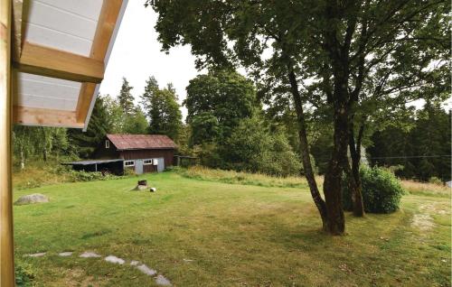 a yard with a tree and a house at Holiday Home Edsåsen Tallås Ed in Åsen