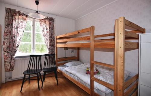 a bedroom with two bunk beds and a table and chairs at Awesome Home In Ed With 3 Bedrooms in Åsen