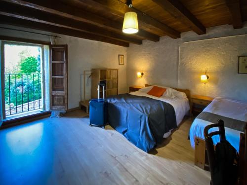 1 dormitorio con 2 camas y ventana en El Buxaus de la Muntanya, en Arbúcies