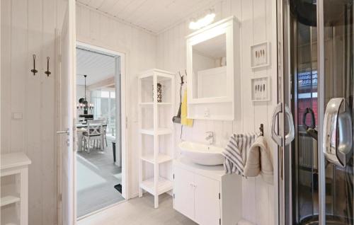 La salle de bains blanche est pourvue d'un lavabo et d'un miroir. dans l'établissement Cozy Home In Zerpenschleuse With Wifi, à Zerpenschleuse