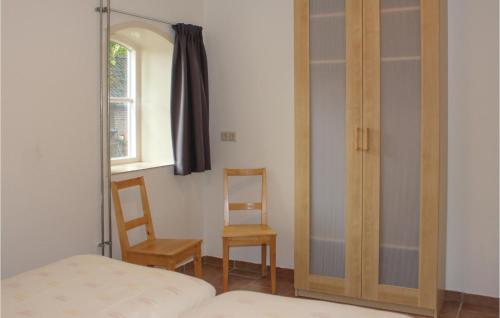 1 dormitorio con espejo, 1 cama y 1 silla en Nice Home In De Moer With House A Panoramic View, en De Moer