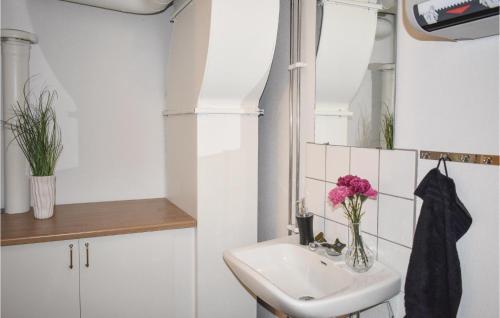 łazienka z umywalką i wazonem kwiatowym w obiekcie 4 Bedroom Gorgeous Apartment In Finspng w mieście Kolvetorp