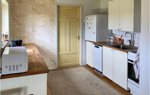 a kitchen with white cabinets and a white refrigerator at Pet Friendly Home In Hjärnarp With Wifi in Hjärnarp