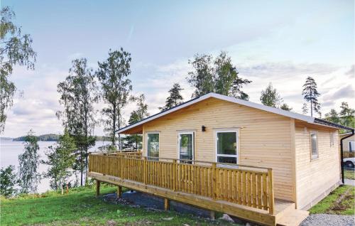 a tiny house with a large deck next to a lake at Beautiful Home In Dalslånged With Wifi in Dals Långed